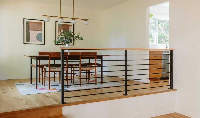 Modern dining room remodel with mid-century chairs, designer pendant lighting, and wide-plank hardwood floors