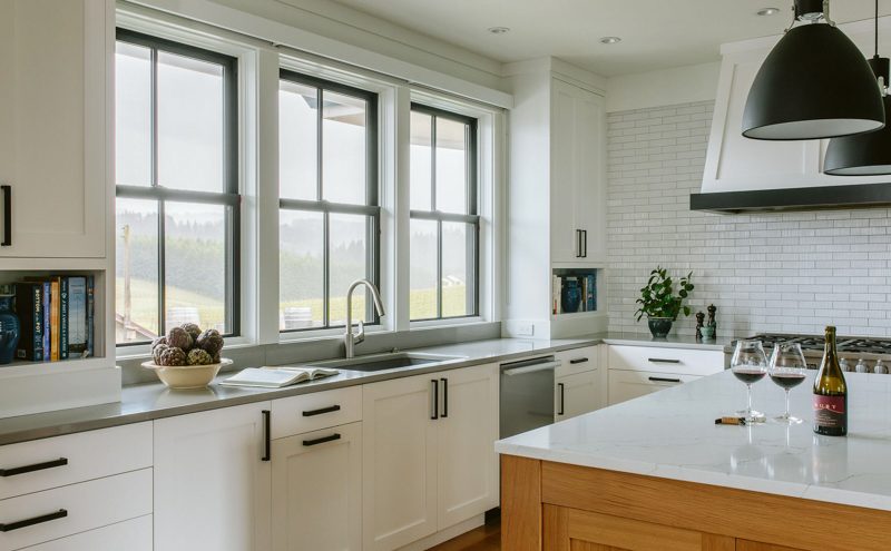 Bright white kitchen remodel with shaker cabinets, quartz countertops, subway tile backsplash, and large windows overlooking the hills