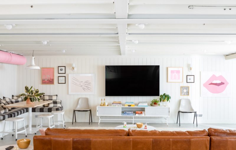 Elegantly remodeled living room with white walls, leather sofa, and modern entertainment area.